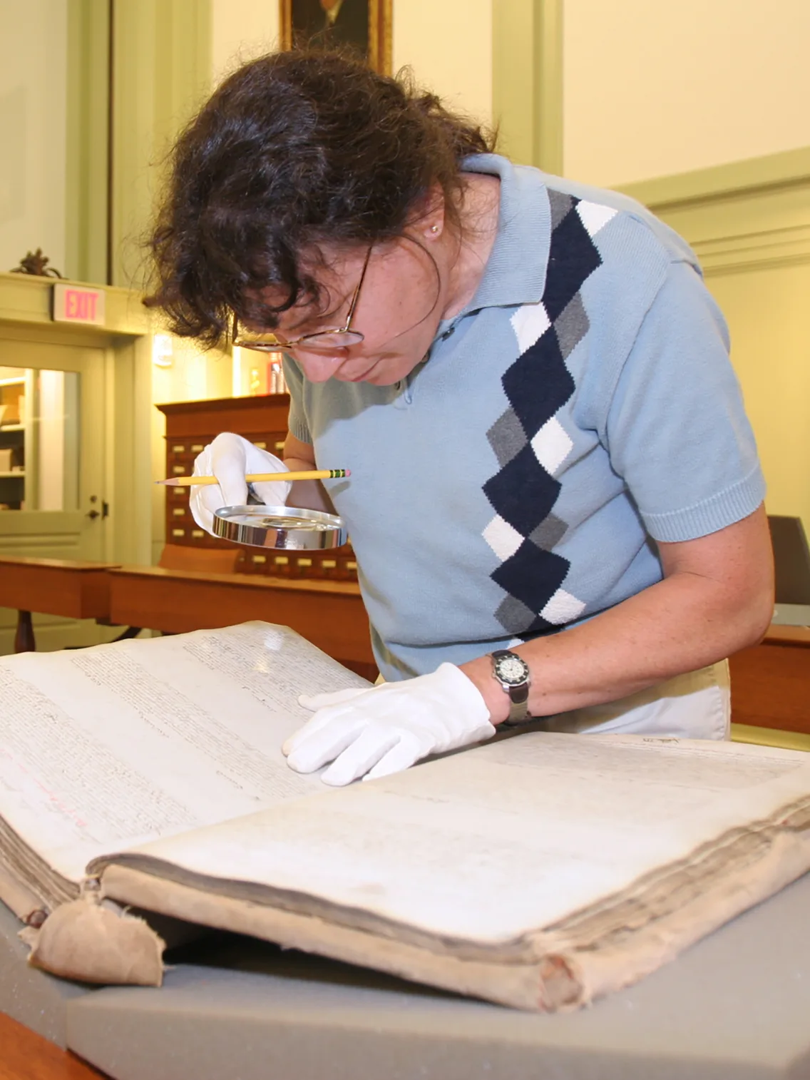 A researcher examining an historical document in the de Gaspe Beaubien Reading Room in Baker Library | Bloomberg Center.