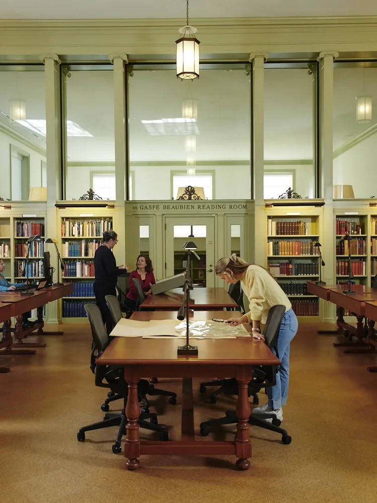 Researchers working at multiple tables in reading room