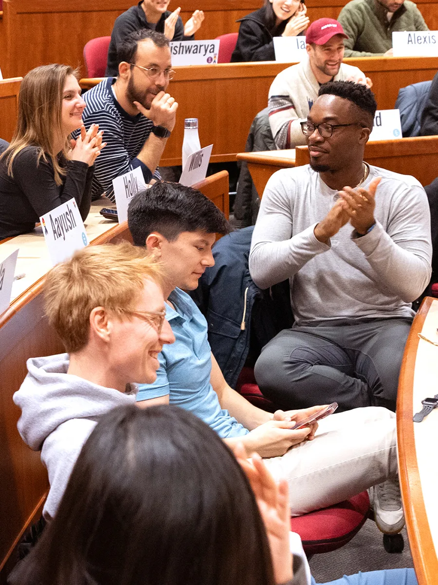 MBA students celebrating an answer during a case discussion.