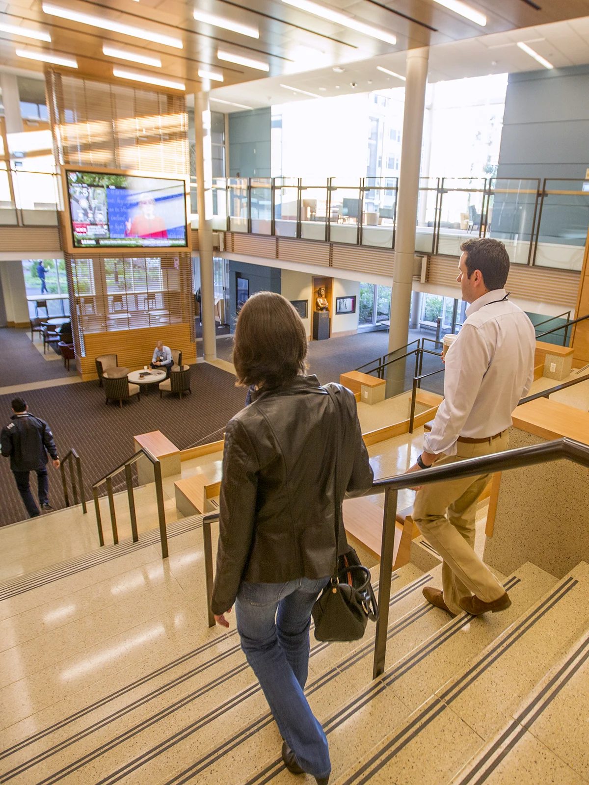 People walk down the stairs inside Chao Center with a view of the building interior