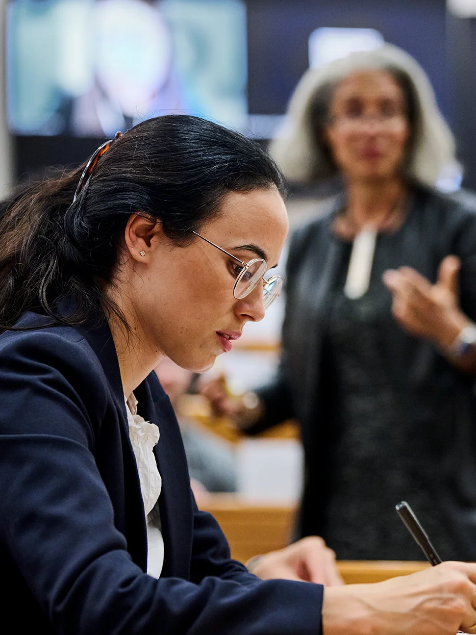 A female participant taking notes in a classroom setting