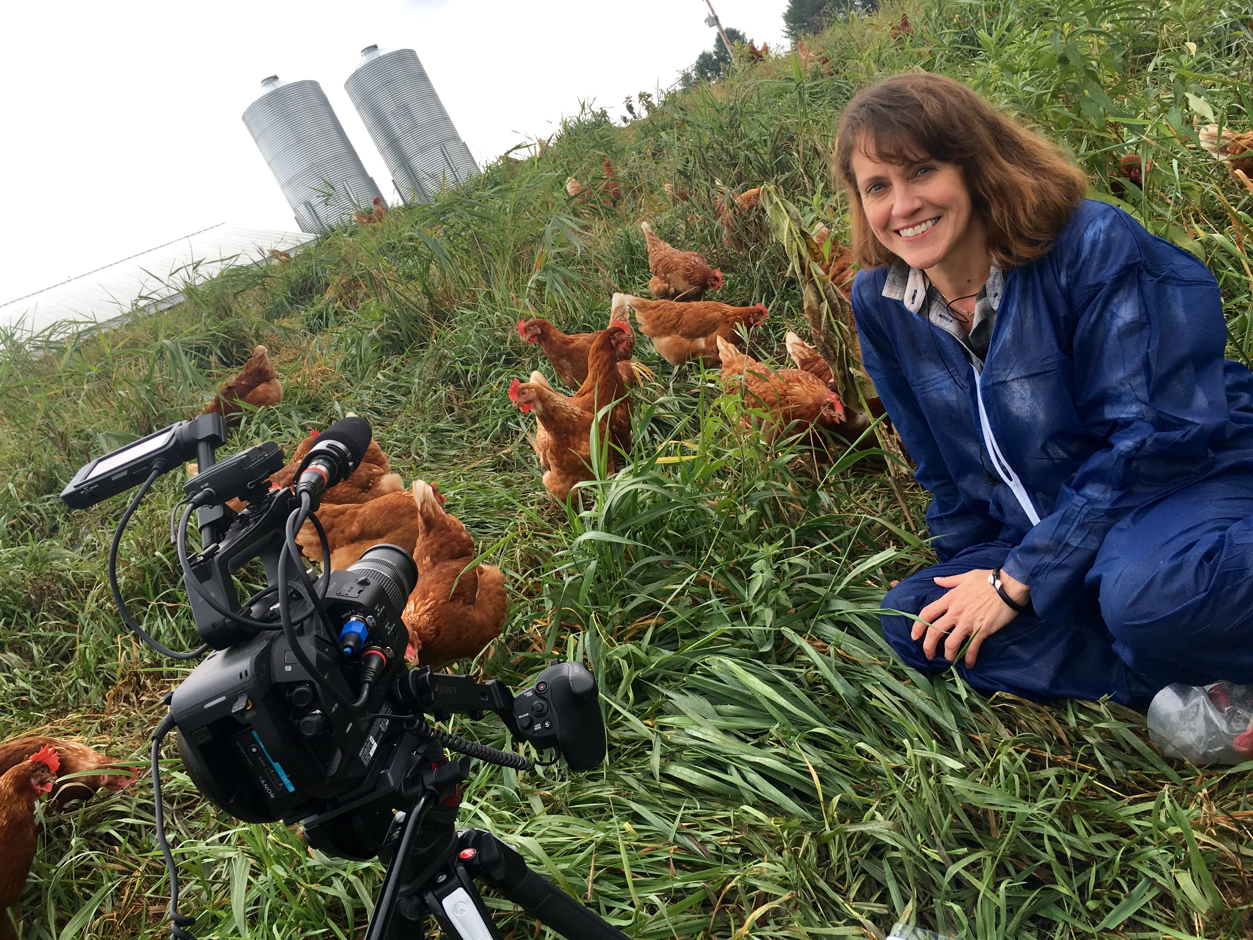 Ruth with a camera and chickens.