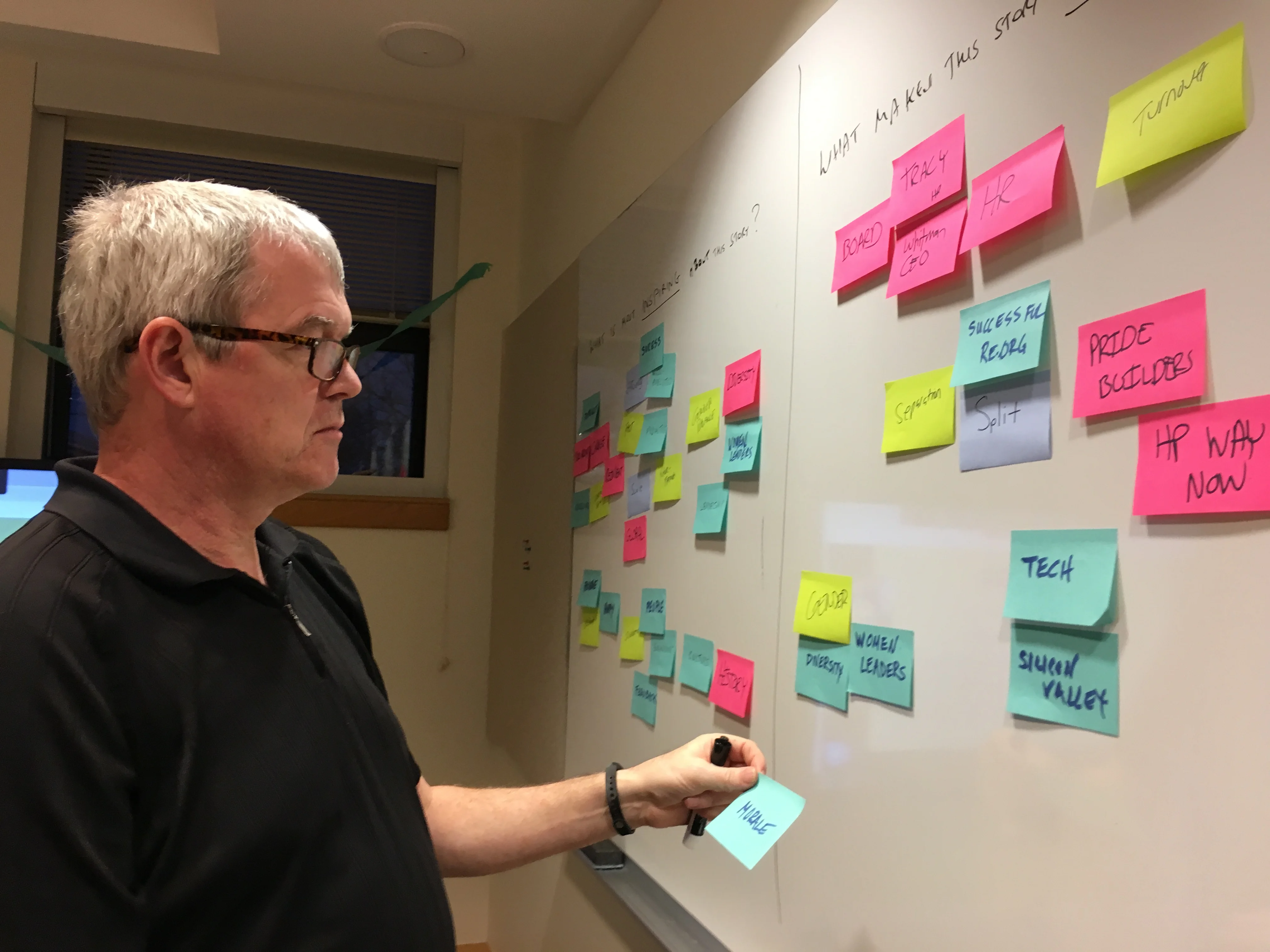 A man in front of a sticky note storyboard. 
