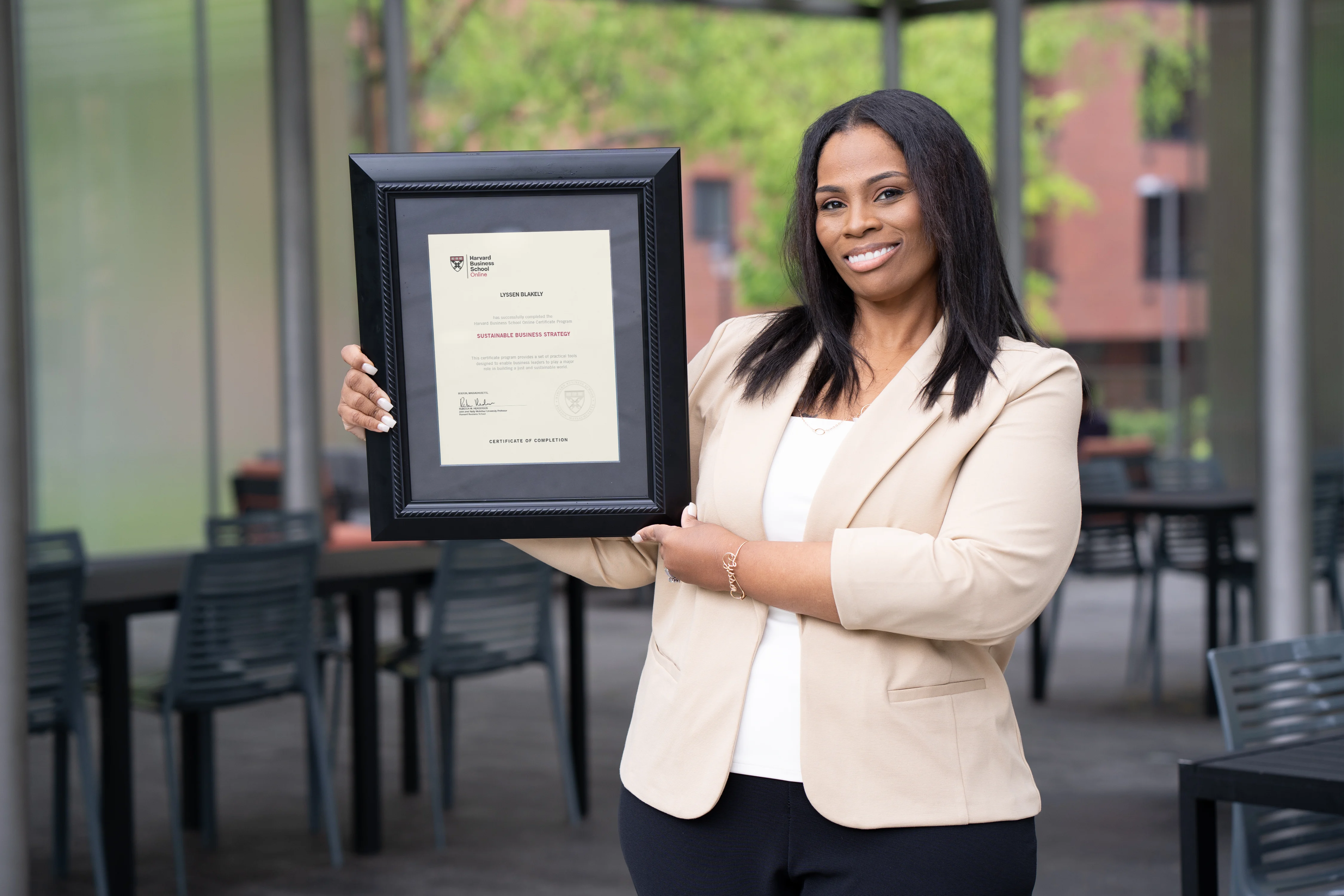 HBS Online learner Lyssen Blakely holding her Certificate of Completion.