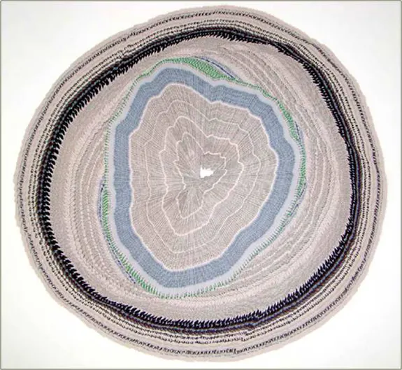 Sculptural tree cross-section made from folded newspaper, forming 195 concentric rings.