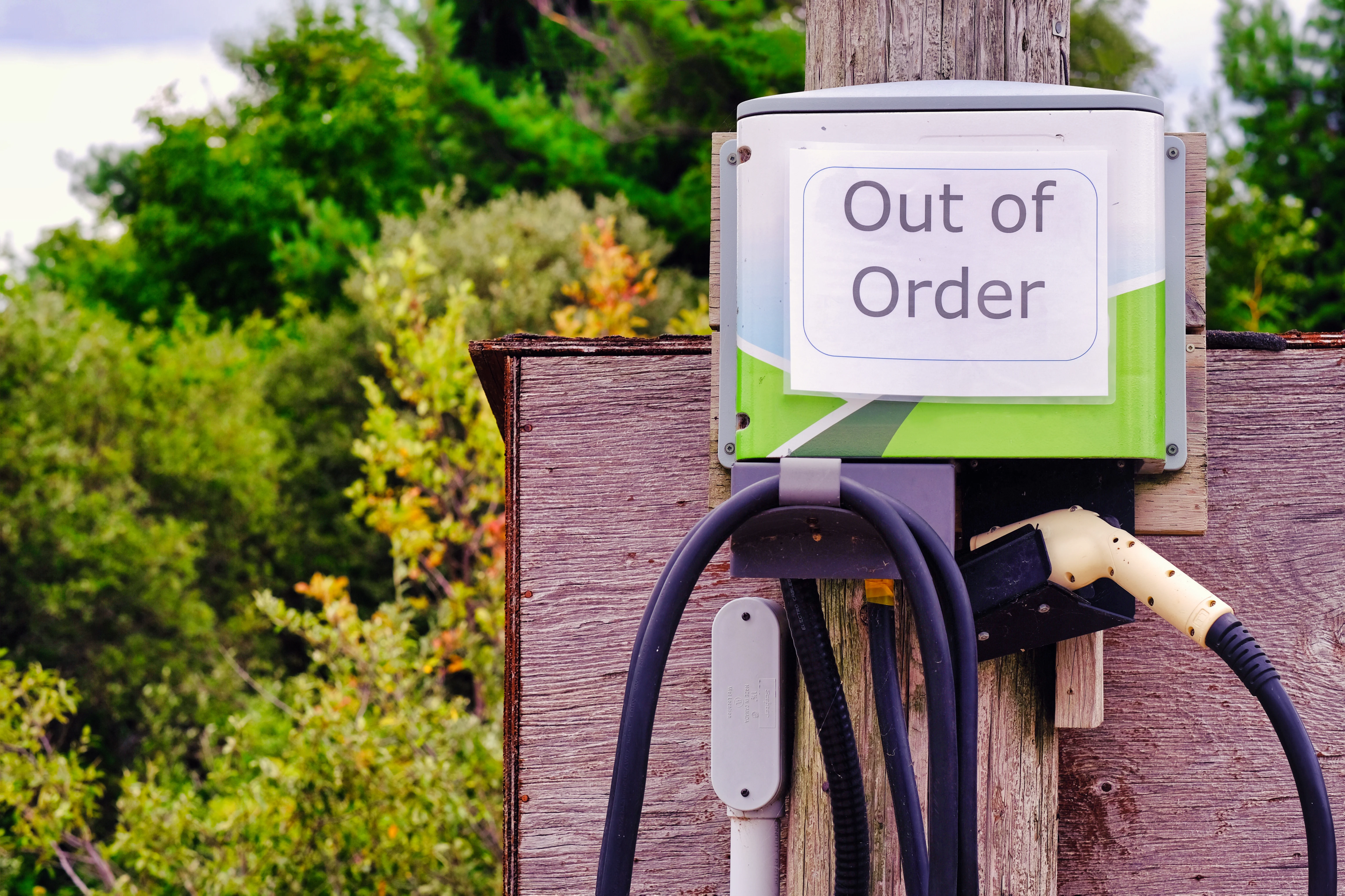 "Out of order" sign displayed on an electric vehicle charging station.