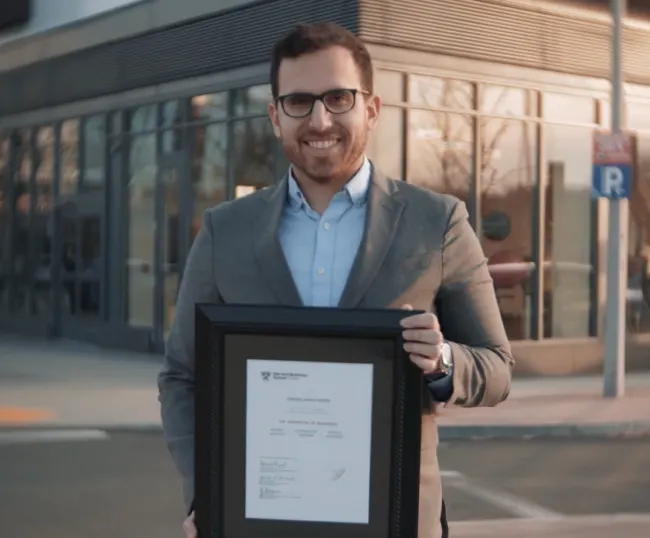 A person stands outside, holding their certificate of readiness.
