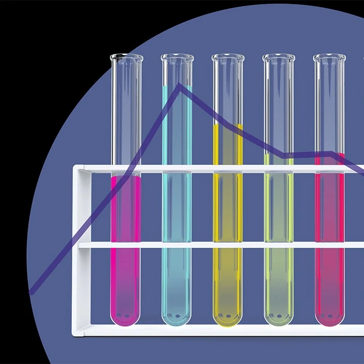 Test tubes of different colors on a rack against a purple background. 