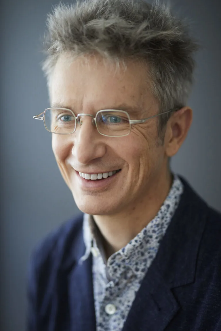 Spencer Glendon standing in front of a gray background