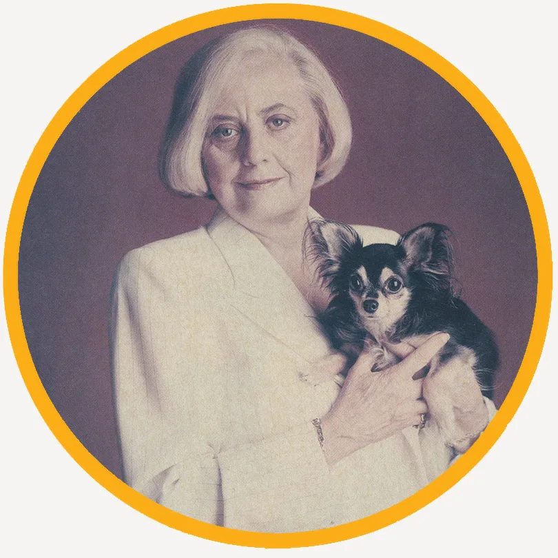 Muriel Siebert in a white suit holding her small dog, Monster, portrait against a burgundy background