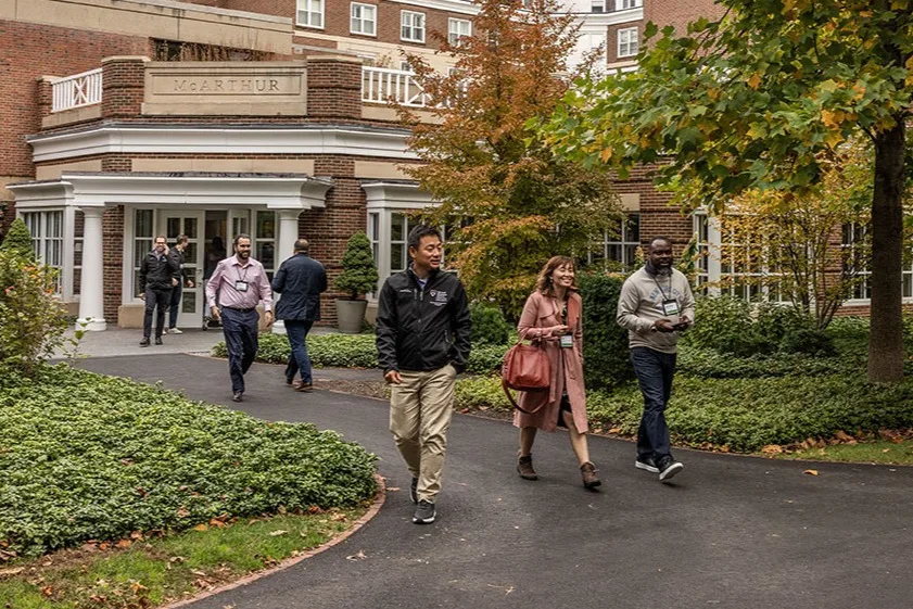 Executive participants walk outside McArthur and onto the HBS campus