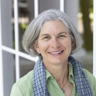 Michelle O'Day headshot in green shirt and scarf smiling