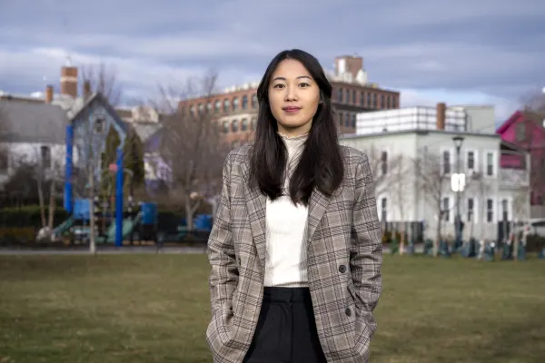 Sue Jia (MBA 2025) in front of affordable housing complex
