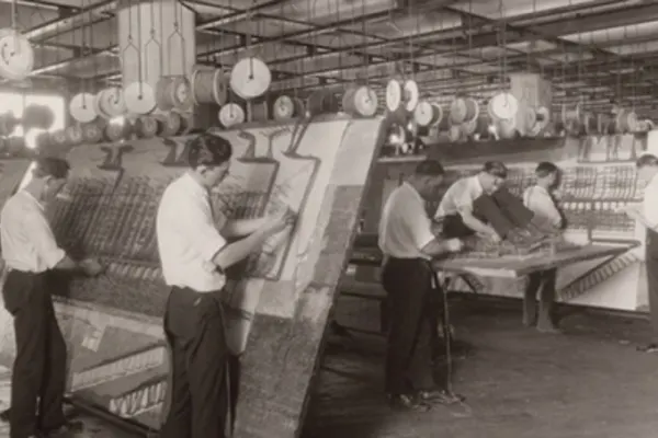 Workers at Western Electric's Hawthorne Works plant. Men complete tasks at various workstations in sepia tones.