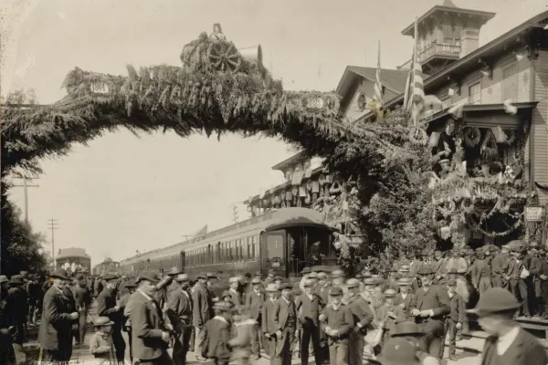Group of men gathered in front of arch covered in flowers