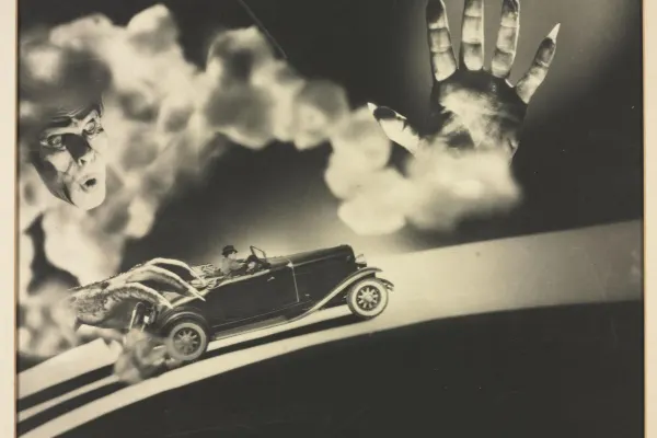 Face floating in cloud of smoke, looking down at his hands holding a car