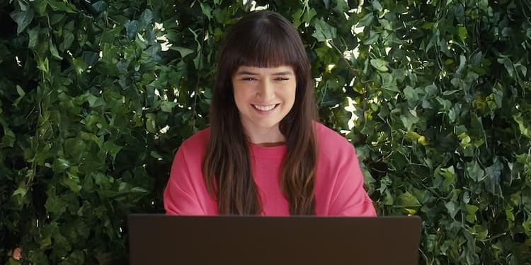 Working mom on her laptop with ivy growing behind her
