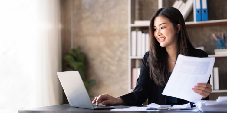 Business professional at a desk, working at a laptop.