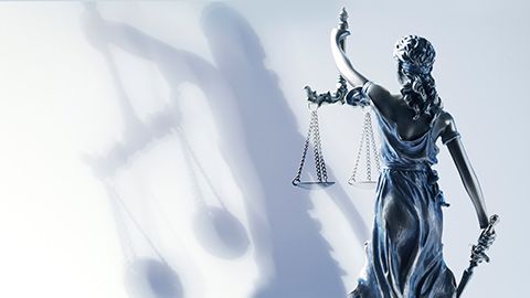 looking from behind of lady justice against white background