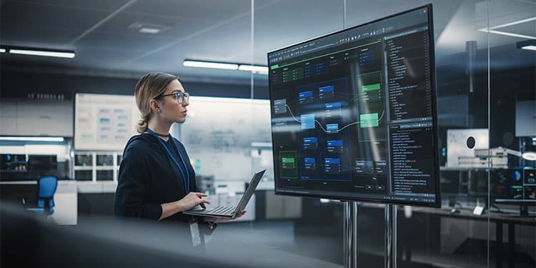 Engineering professional doing quality assurance on software code on big screen