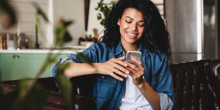 Woman sitting down engaging on her cell phone.