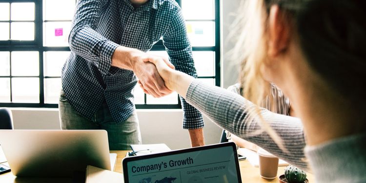 Colleagues shaking hands while working at a startup