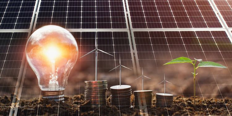 Lightbulb, wind turbines, plant, and stacks of coins in front of solar panels to illustrate climate finance