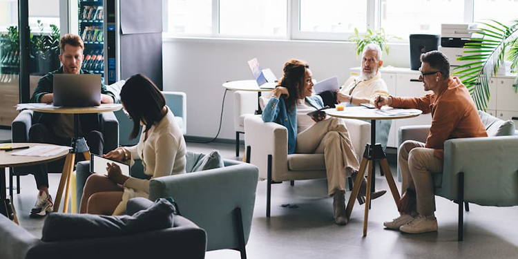 Employees gathered in a common area working together on a project.