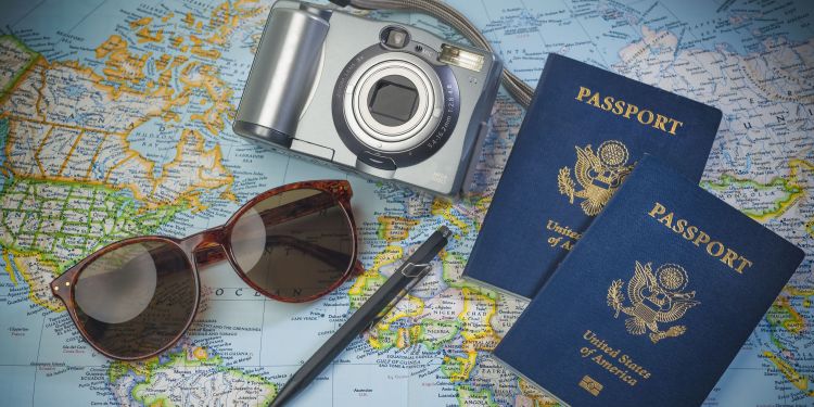 Sunglasses, camera, and passports laying on a map