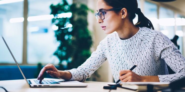 Aspiring female entrepreneur researching innovative business ideas on a laptop