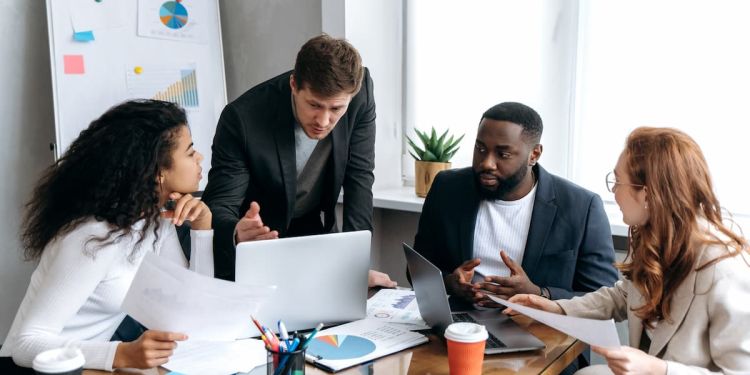 A team of four business professionals discussing strategy at a conference table
