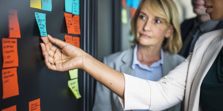 Business professionals using sticky notes to plan organizational change