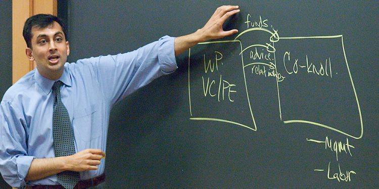Professor Mihir Desai teaching at a blackboard