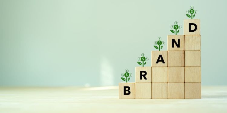 Building blocks spelling "brand" with money icons above each letter and step