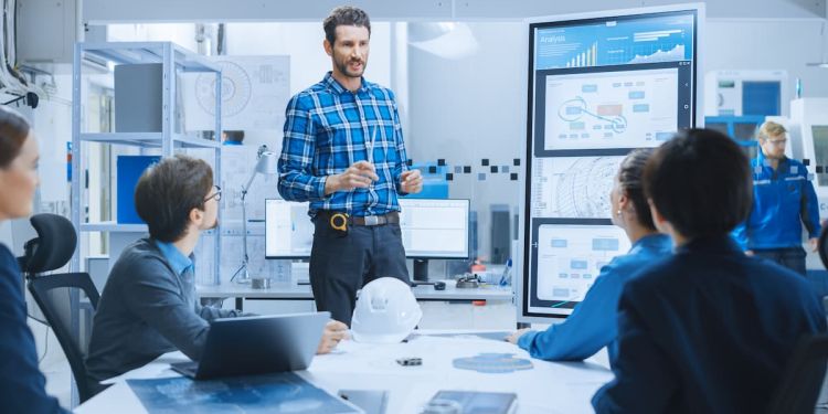 Engineering leaders presenting to a team in a conference room