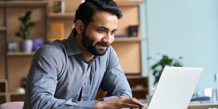 An online learner using their laptop at a table