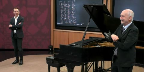 Organizational expert Frank Barrett and HBS professor Ethan Bernstein stand next to a piano during a lecture in the HBS Live Online classroom.