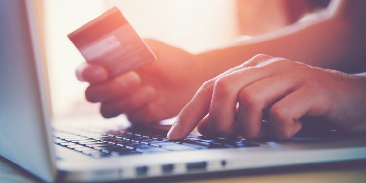 Person entering credit card information into a laptop