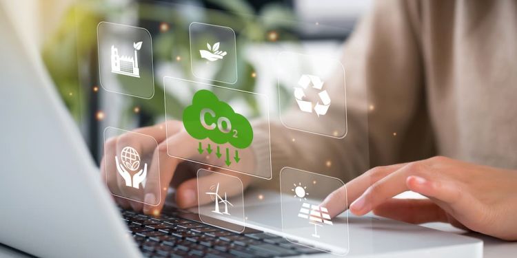 Person using a laptop with cliamte change icons floating above it, including the recycling symbol, a solar panel, and windmills