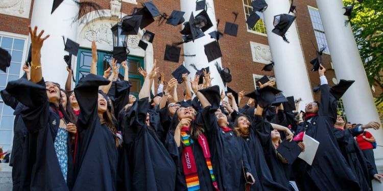 Harvard Business School MBA graduates throw their graduation caps